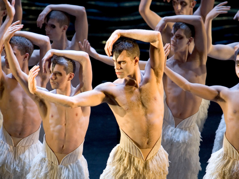 Production image of Matthew Bourne's Swan Lake dancers performing in 2005, wearing white feathered pants.